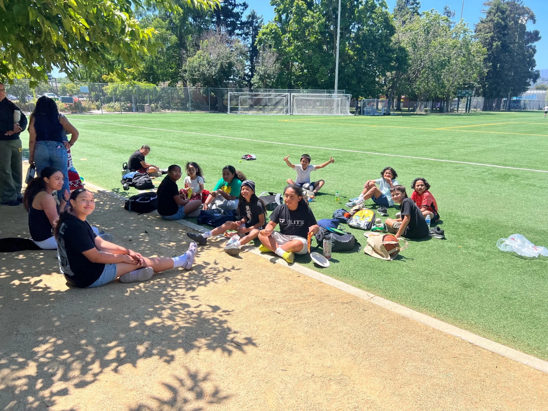 Students gathering together beside an outdoor athletic field