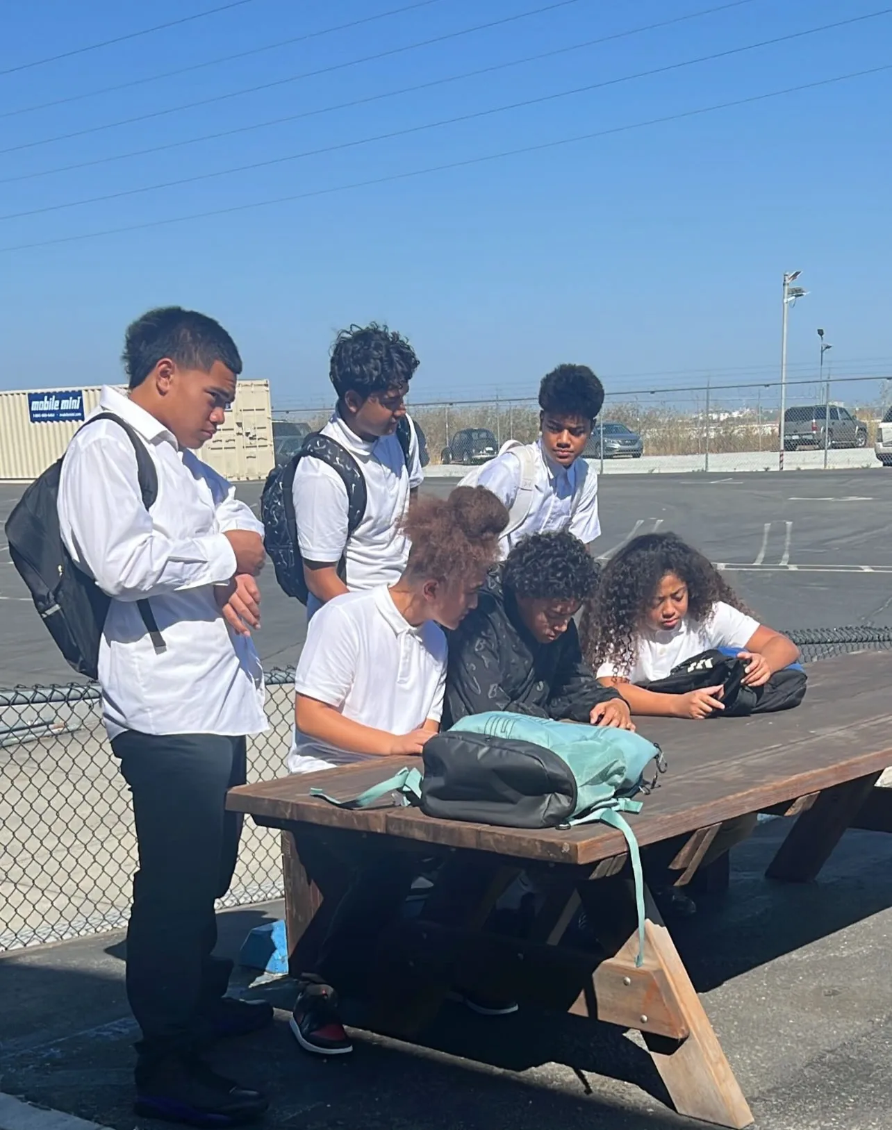 Students working together outdoors at a table